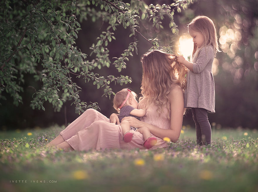 La madre di allattamento al seno il suo bambino figlio seduto in poltrona  accogliente vicino ad albero di Natale, inverno Foto stock - Alamy